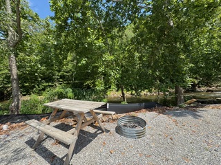 Shaded campsite with picnic table and fire ring